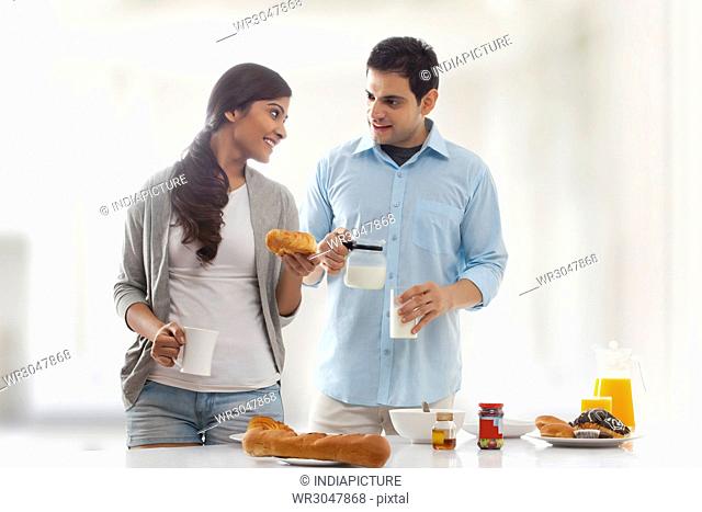 Young couple having breakfast at kitchen table
