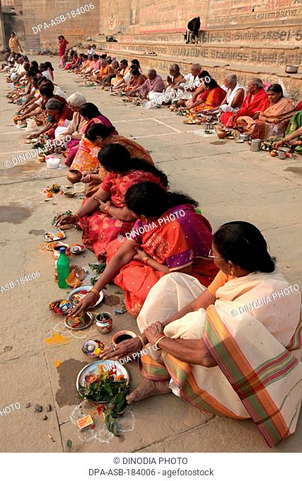 Devotees eating food after religious ritual Ganga River ghat at Varanasi Uttar Pradesh India
