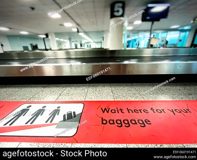 A red patch on the floor indicating where to wait for baggage claim at an airport. Icons and pictogram. Arrival at the airport
