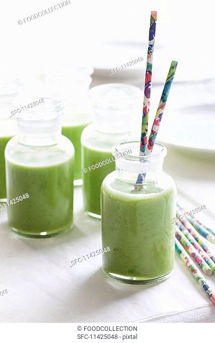 Cold pea soup in bottles with straws
