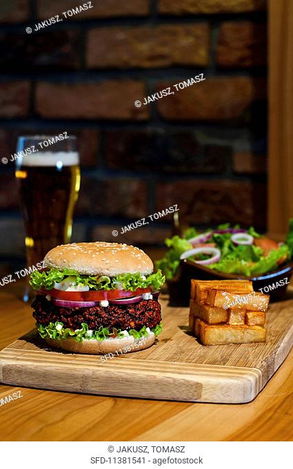 A hamburger, chips and a mixed leaf salad