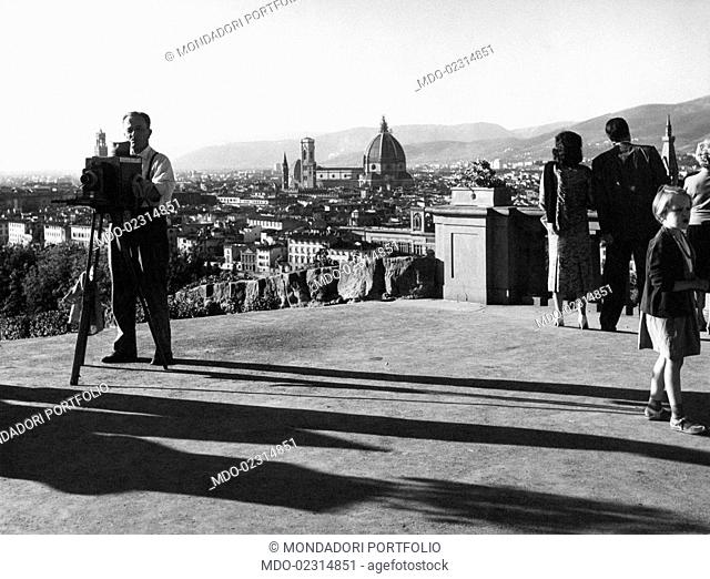 People watching the view from piazzale Michelangelo. In the background, the cathedral with the dome by Brunelleschi. Florence, 1950s