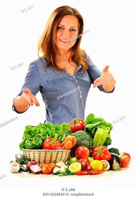 Young woman with variety of vegetables isolated on white