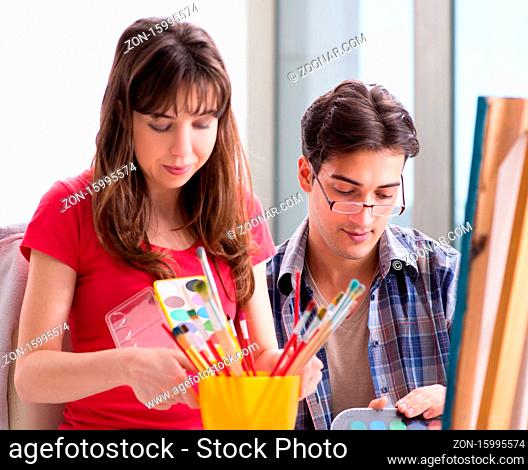The artist coaching student in painting class in studio