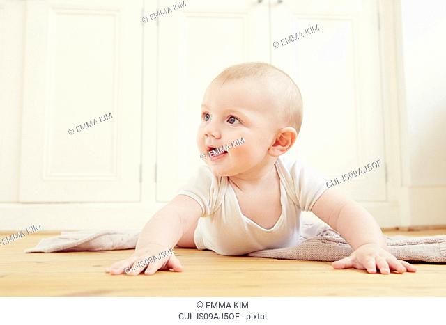 Smiling baby boy crawling on floor