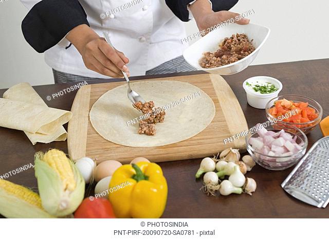 Female chef preparing fajita in the kitchen