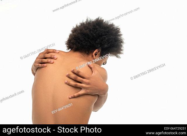 Back pain. Curly-haired african american guy suffering from pain in his back