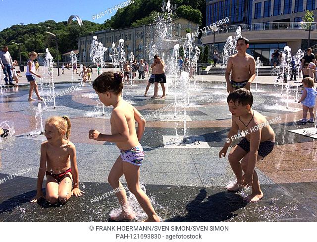 Children playing with a cooling down at a fountain in summer heat, sun, heat, refreshment, water, sweat. general, feature, border motif, Kiev / Ukraine