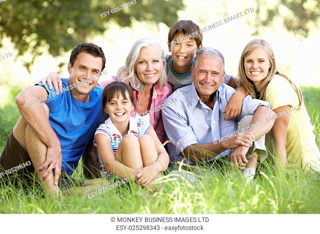 Three Generation Family Relaxing In Summer Field