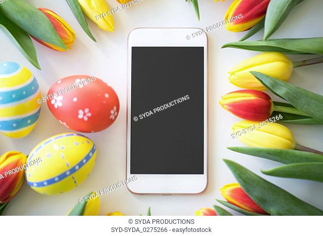 smartphone with easter eggs and tulip flowers