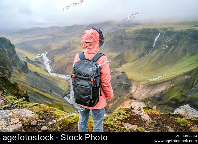 Woman hiker with backpack enjoying icelandic highland and river fossa close to Haifoss waterfall in Iceland