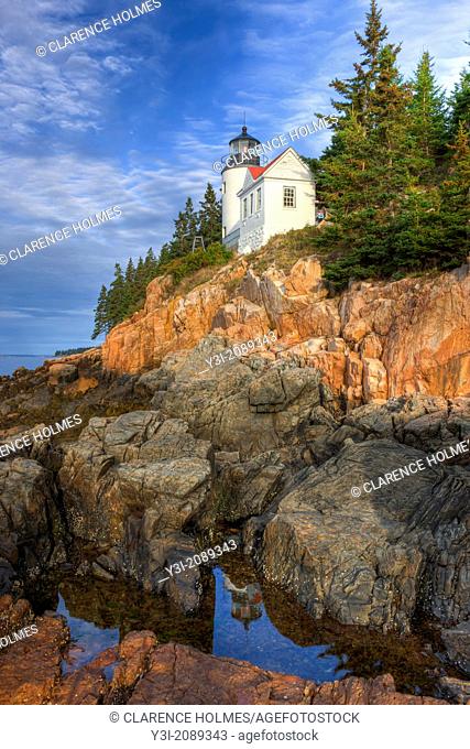 Bass Harbor Head Lighthouse is reflected in a tidal pool as it overlooks the entrance to Bass Harbor and Blue Hill Bay in Tremont, Maine