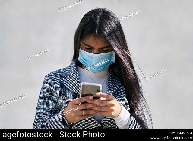 Girl with a mask to avoid contagion walking down the street. Coronavirus concept