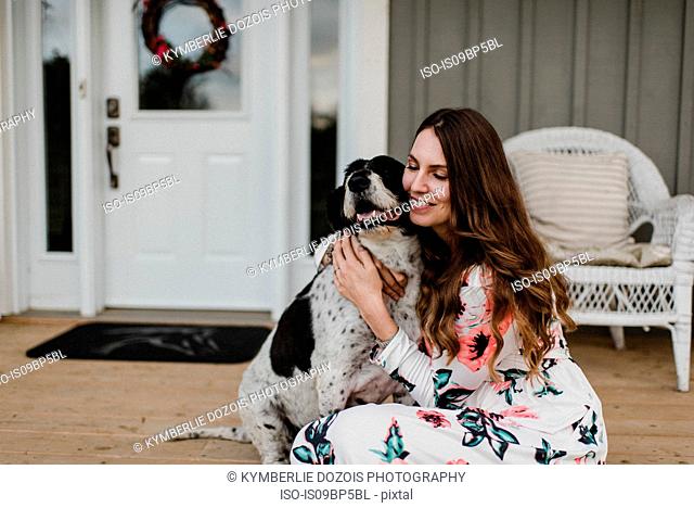 Woman and her dog sitting on porch