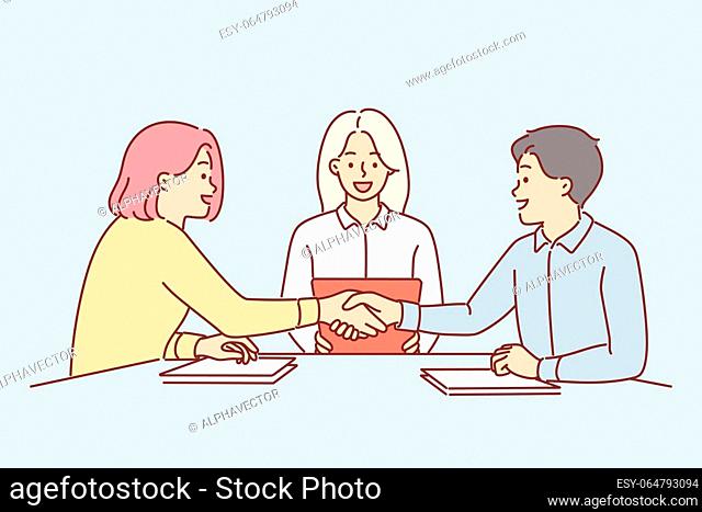 Handshake of business partners sitting at negotiating table, discussing terms of deal. Handshake of man and woman after conclusion of marriage contract that...