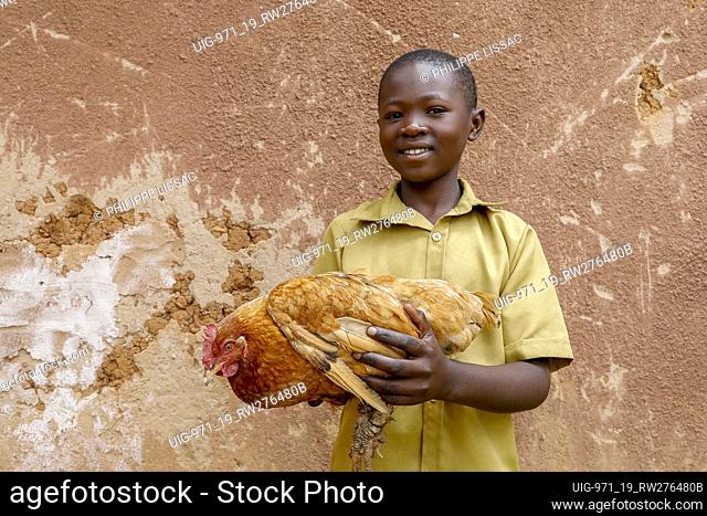 Boy holding a chicken in a village near Gicumbi, northern province, Rwanda