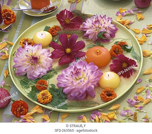 Summer flowers and floating candles on pale green plate