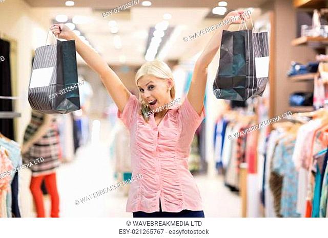 Woman standing in a shop stretching arms in the air