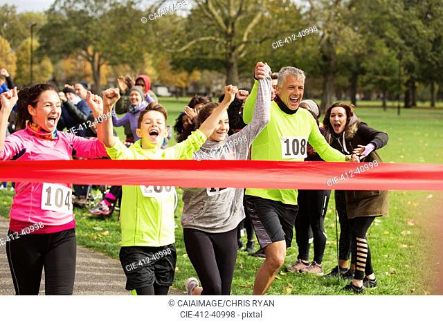 Enthusiastic family running, nearing charity run finish line