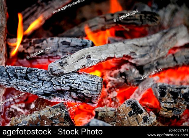 Wooden embers close-up on a whole background