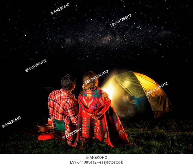 Picknic and camping concept, man and lady sit and look at star, milky way and meteor, love and valentine day