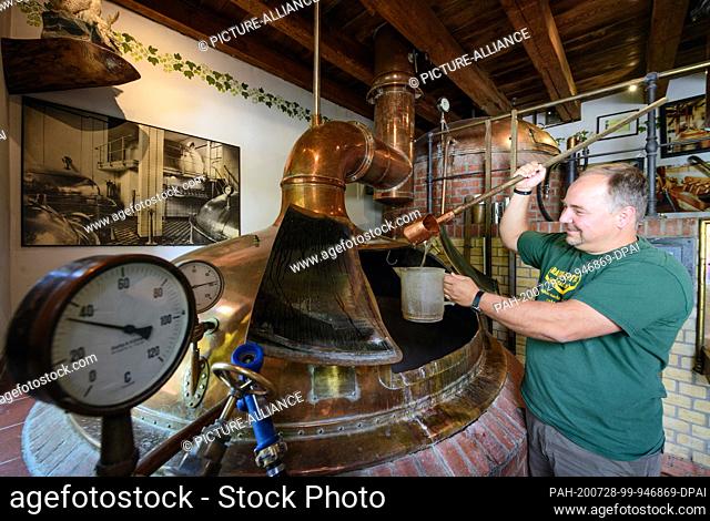 24 July 2020, Brandenburg, Potsdam: Master brewer Thomas Köhler from the Forsthaus Templin brewery stands in front of the brewing kettle and measures the...