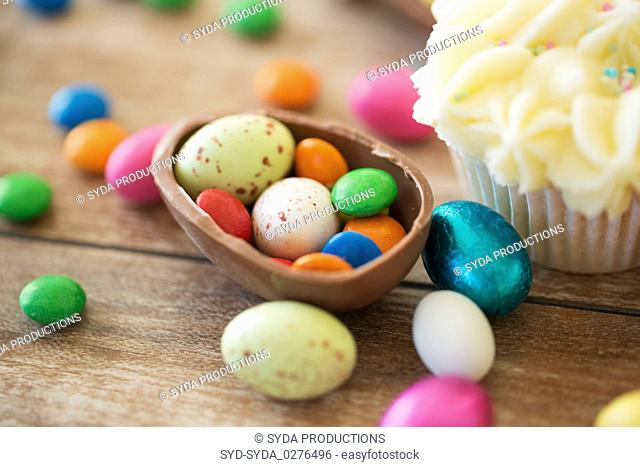 close up of chocolate egg with candies and cupcake