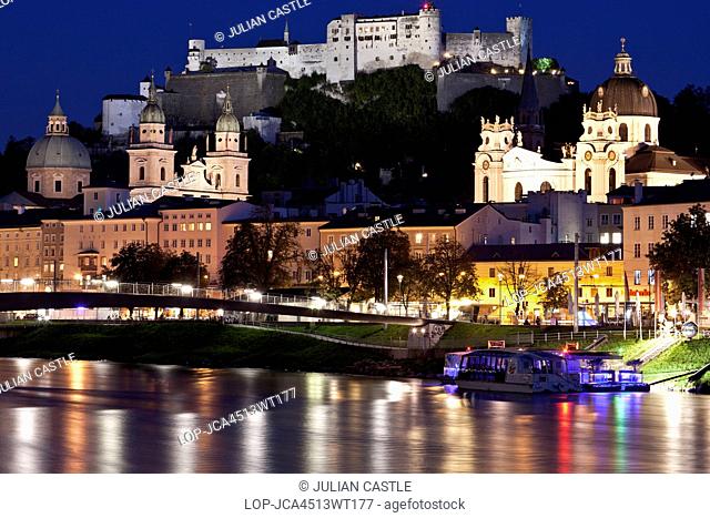 Austria, Salzburger Land, Salzburg. City view at night of the Salzach river with Baroque churches and Hohensalzburg fortress