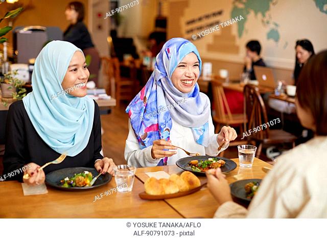 Young South-east Asian women eating at restaurant