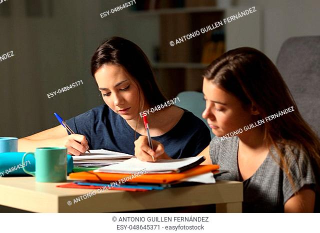Two studious students studying hard late hours in the night at home