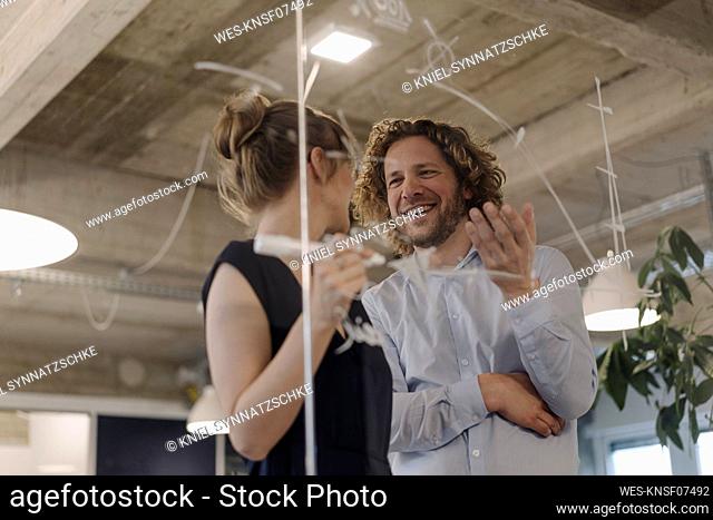 Smiling businessman and businesswoman working on a project in office