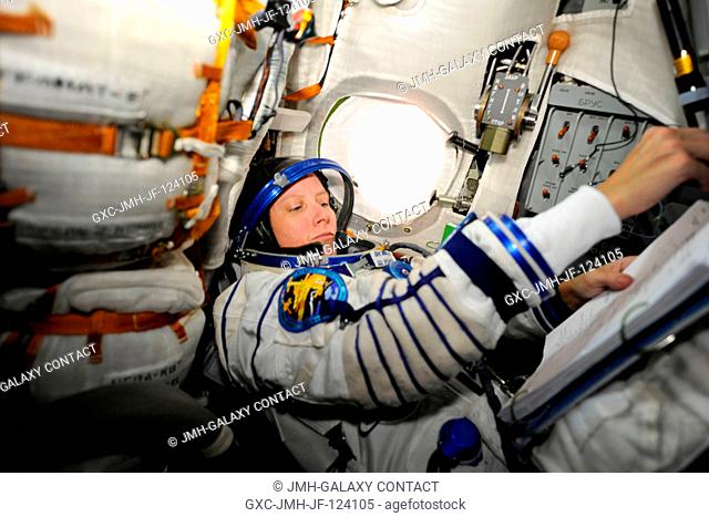NASA astronaut Shannon Walker, Expedition 24 flight engineer, attired in her Russian Sokol launch and entry suit, occupies her seat in the Soyuz TMA-19...