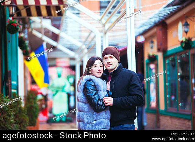 Romantic couple walking in the winter under the snow in Christmas time
