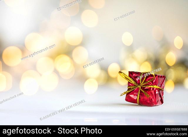 christmas present red and silver baubles against bokeh lights gold shiny glitter background with copy space, space for text