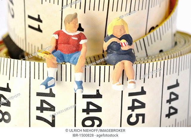 Overweight figures sitting on a tape measure
