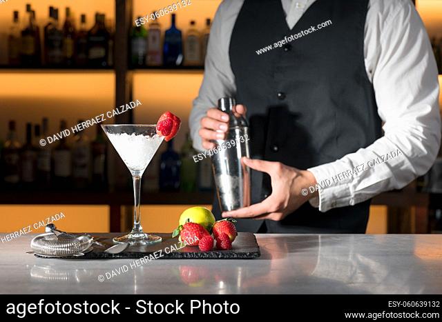 Expert barman is making cocktail at night club. High quality photography