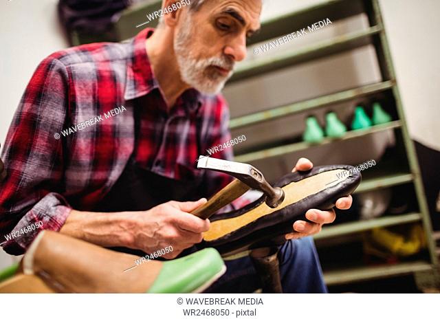 Cobbler hammering on the sole of a shoe