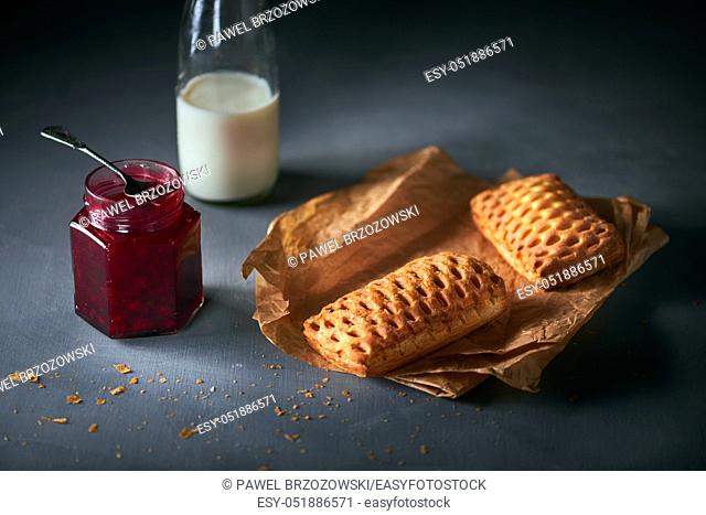 Buns with cranberry jam and bottle of milk
