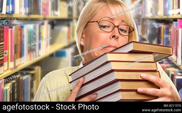 Beautiful expressive student or teacher with books in library