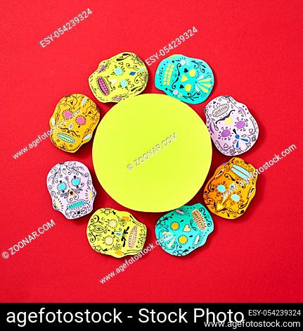 Handcraft paper Calaveras attributes of the Mexican holiday Calaca are decorated with a round yellow frame on a red background with space for text