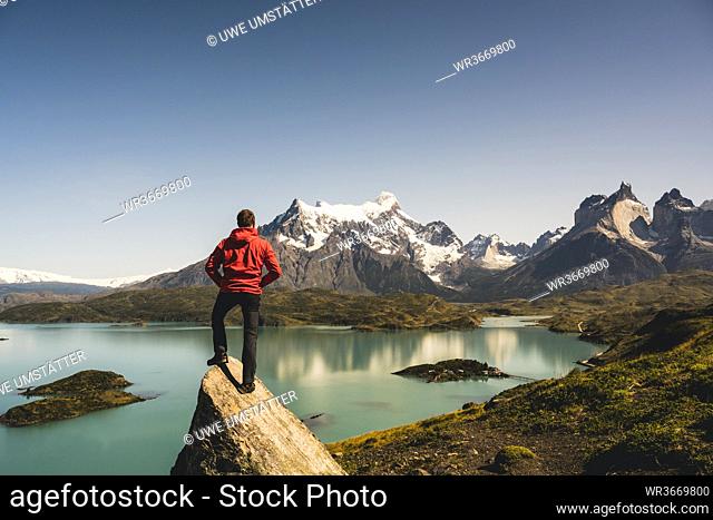 Man standing on rock at Lake Pehoe in Torres Del Paine National Park, Chile Patagonia, South America