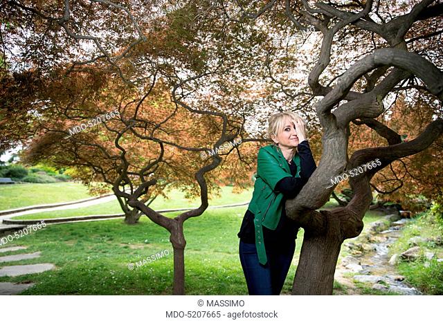 Actress and comedian Luciana Littizzetto leaning against a tree inside the public park Parco del Valentino. Turin, Italy. 21st April 2016
