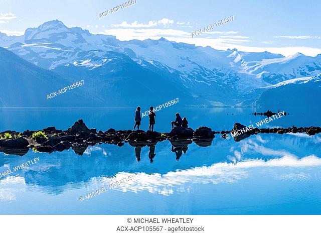 Hikers navigate rock stepping stones at Garibaldi Lake, Garibaldi Provincial Park, British Columbia, Canada