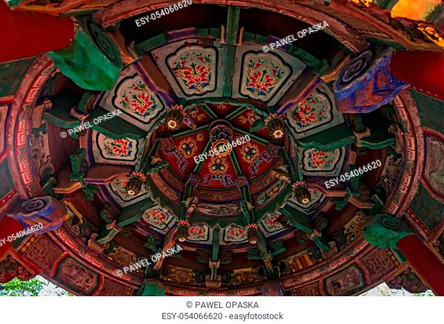 Decorative colorful paintings on the ceiling of an altar of Buddhist temple at the foot of Huashan mountain, Xian, Shaanxi Province, China