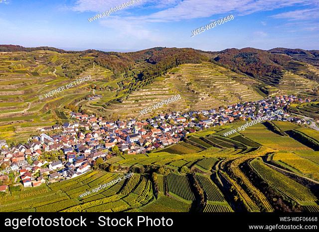 Germany, Baden-Wurttemberg, Vogtsburg im Kaiserstuhl, Aerial view of countryside village and terraced vineyards in Kaiserstuhl