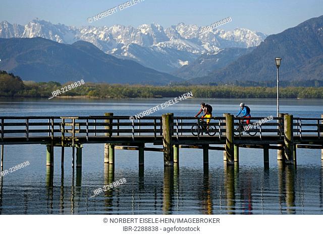 Cyclists on electric bicycles on the pier at Chieming, Chiemsee lake, Chiemgau region, Upper Bavaria, Bavaria, Germany, Europe