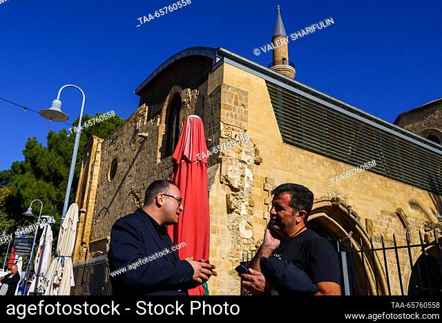 CYPRUS, NICOSIA - 14 de diciembre de 2023: Los hombres charlan fuera de la mezquita de Selimiye, una catedral cristiana hasta el siglo XVI