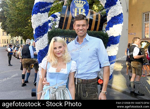 08 September 2021, Bavaria, Munich: Designer Sonja Kiefer and Cedric Schwarz show off at the presentation of the Wiesnplaymate 2021 in front of the Parkcafe