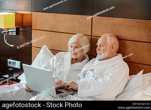 Interesting video. Two seniors watching something on laptop and looking interested