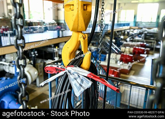 30 May 2022, Berlin: A cable is attached to a crane hook at the old wastewater pumping station for Charlottenburg on Sophie-Charlotten-Strasse with a loop of...